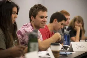 smiling student seated at a crowded table