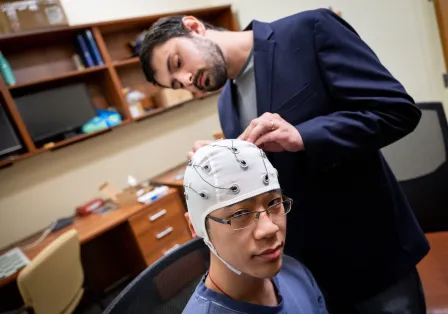 Matthew Singh adjusts electrodes