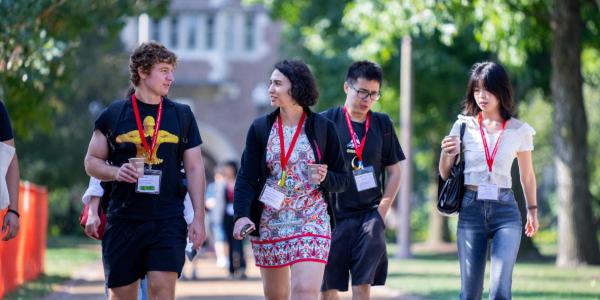 Incoming graduate students walk and talk on campus.