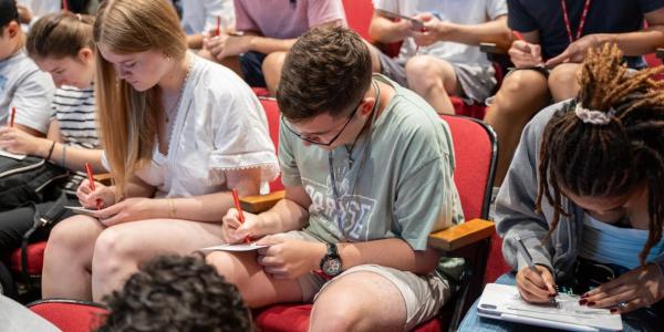 A&S freshmen site in an auditorium and write postcards to their future selves.