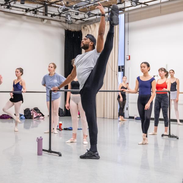 Man doing a balletic motion, with his leg raised into the air.