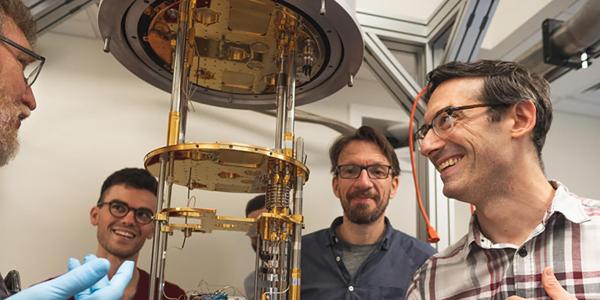 Henriksen inspects a device in the university’s dilution refrigerator laboratory with collaborators from the Center for Quantum Leaps.