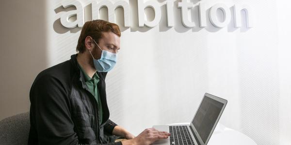 Masked student at laptop