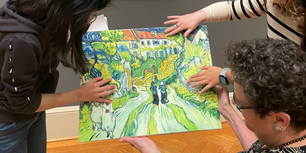 Three people hold a recreation of an original painting and run their hands across the surface of the canvas as part of Saint Louis Art Museum's 